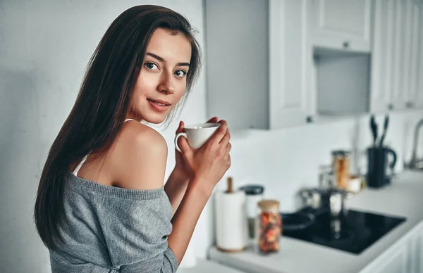 Good morning! Attractive young woman is having rest at home. Girl on kitchen.