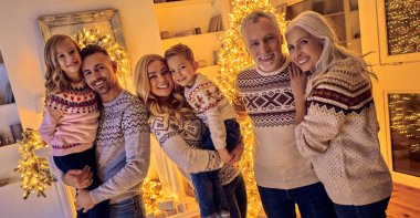 Mutlu Noeller ve mutlu yeni yıl! Mutlu aile kutluyor kış tatili evde. Büyükanne ve büyükbaba, ebeveynler ve çocuklar birlikte dekore edilmiş yılbaşı ağacının yanında ayakta iken Noel için bekliyor