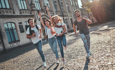 Bir grup genç insan ders birlikte üniversitede. Öğrenciler açık havada.