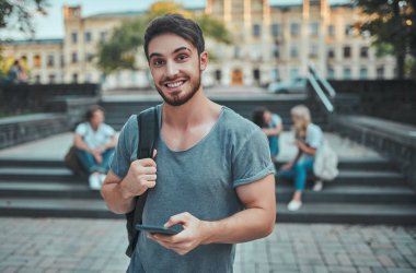 Bir grup genç insan ders birlikte üniversitede. Öğrenciler açık havada.