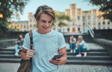 Bir grup genç insan ders birlikte üniversitede. Öğrenciler açık havada.