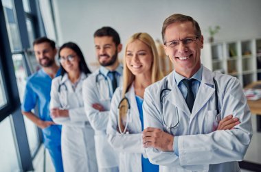 Birlikte klinikte çalışan doktorlar grubu. Sağlık personeli üniformalı.