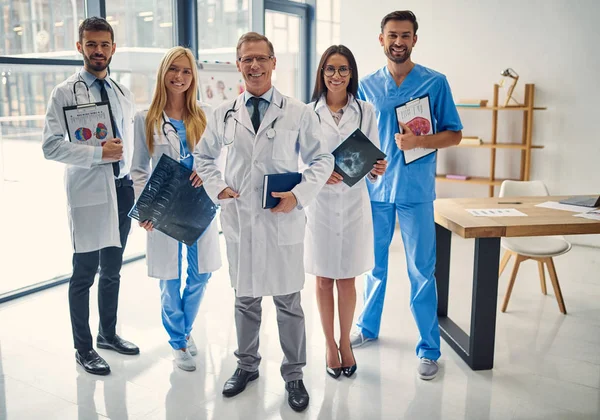 Group of doctors working together in clinic. Medical personnel in uniform.