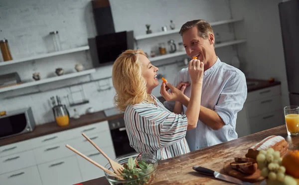 Senior couple is cooking on kitchen. Beautiful woman and handsome man are spending time together at home. Healty lifestyle concept.