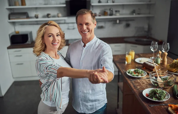 Senior couple is cooking on kitchen. Beautiful woman and handsome man are spending time together at home. Healty lifestyle concept.