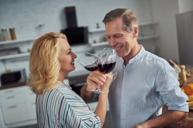 Üst düzey çift mutfak yemek pişiriyor. Güzel kadın ve yakışıklı adam birlikte evde vakit. Romantik bir akşam yemeği