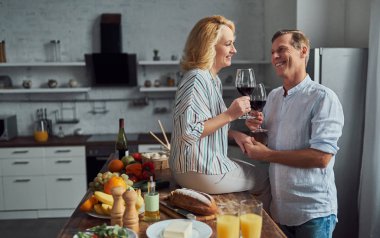 Üst düzey çift mutfak yemek pişiriyor. Güzel kadın ve yakışıklı adam birlikte evde vakit. Romantik bir akşam yemeği