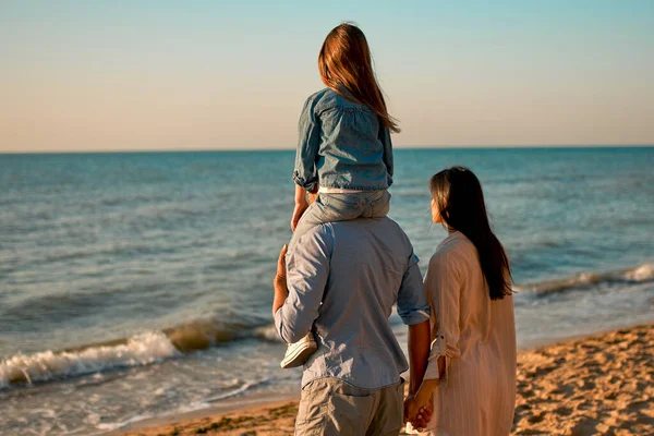 快乐的家庭观念 年轻迷人的妈妈 英俊的爸爸和他们可爱的小女儿一起在海滩上散步 — 图库照片