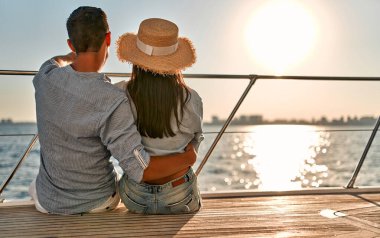 Yat güvertesinde denize açılırken aşık bir çift oturuyor. Yakışıklı bir erkek ve güzel bir kadının romantik bir randevusu var. Lüks seyahat kavramı.