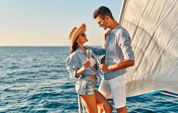 海を航海しながらヨットデッキに立つカップル ハンサムな男と美しい女性はロマンチックなデートを持っています ラグジュアリートラベルコンセプト — ストック写真