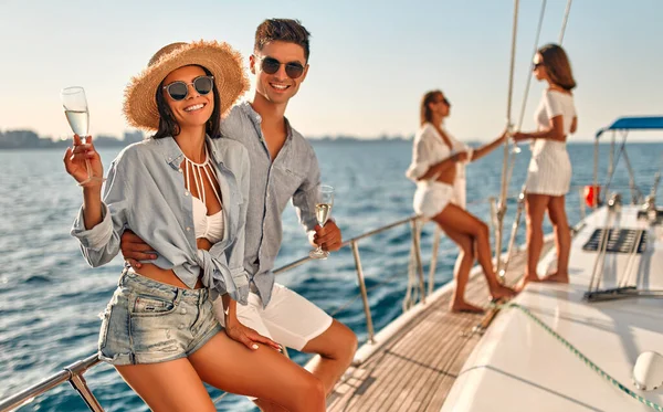 Group of friends relaxing on luxury yacht. Having fun together while sailing in the sea. Traveling and yachting concept.