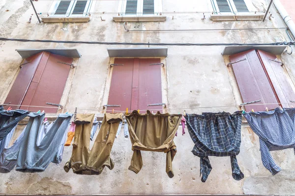 Erkekler Rovinj kasaba, Hırvatistan, Avrupa'nın eski bir ev cephesinde asılı Çamaşırhane yıkanmış.
