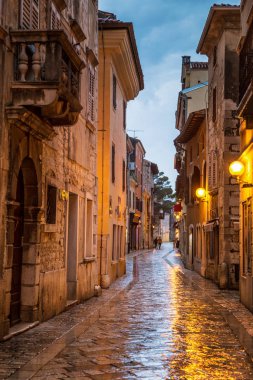 Street in Porec town illuminated by lamps at the evening, Croatia, Europe. clipart