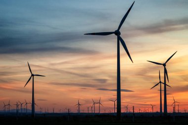Grup Rüzgar güç türbinleri bir gün batımında.