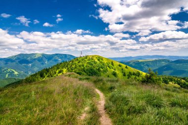 Manzara mavi gökyüzü bulutlu arka planda otsu çayır ve dağ zirveleri ile bahar. Donovaly alan Velka Fatra Milli Parkı, Slovakya, Avrupa.