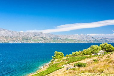 Brac Adası'nda Hırvatistan, Europe bir dağ sahil arka plan ile Adriyatik Denizi üzerinde bir kırsal konut ile bir manzara üzerinde göster.