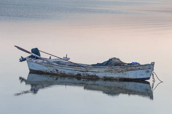 Old fishing small boat on sea.