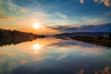 Gün batımında barajın su yüzeyinde manzaranın yansıması. Slovakya 'nın kuzeyindeki Zilina Barajı, Avrupa.