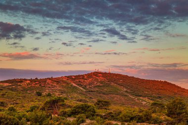 Günün renkli şafağında Primosten kasabası yakınlarındaki Loreto Heykelimizle Tepe, Hırvatistan, Avrupa.