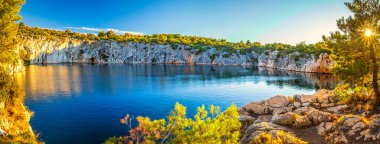 Zmajevo oko 'nun panoramik manzarası, gün batımında Ejderha Gözü Gölü. Hırvatistan 'ın Adriyatik kıyısında popüler bir turizm beldesi olan Rogoznica köyü, Europ