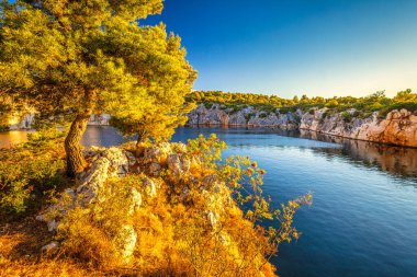 Zmajevo oko, gün batımında Ejderha Gözü Gölü. Hırvatistan, Avrupa 'daki Adriyatik Denizi' nin Dalmaçya kıyısında popüler bir turizm beldesi olan Rogoznica köyü. 
