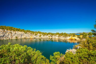 Zmajevo oko, güneşli bir günde Ejderha Gözü Gölü. Hırvatistan, Avrupa 'daki Adriyatik Denizi' nin Dalmaçya kıyısında popüler bir turizm beldesi olan Rogoznica köyü. 
