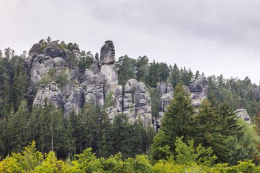 Adrspach-Teplice Kayaları, Avrupa 'nın Çek Cumhuriyeti' ndeki Hradec Kralove Bölgesi 'nde kumtaşı oluşumları. Bulutlu gökyüzüne karşı yeşil bir ormandan yükselen taş oluşumları sakin bir doğal manzara yaratıyor..