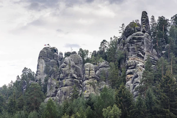 Adrspach-Teplice Kayaları, Avrupa 'nın Çek Cumhuriyeti' ndeki Hradec Kralove Bölgesi 'nde kumtaşı oluşumları. Yükselen kaya oluşumları görkemli bir şekilde yemyeşil bir ormanın ortasında bulutlu bir gökyüzünün altında görkemli ve görkemli bir şekilde yükselir..