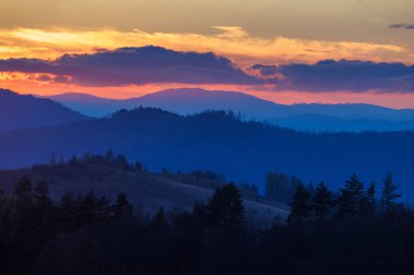 Katmanlı sıradağlar, parlak gündoğumuyla aydınlanır alacakaranlık manzarasında uzun gölgeler bırakır..
