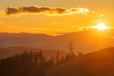 Altın saat dağları aydınlatıyor, sıcak renklerle parıldayan bir gökyüzü, nefes kesici bir gündoğumu sırasında..