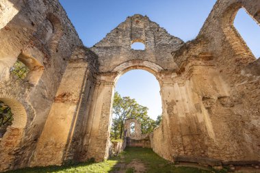 The Katarinka, ruins of a Franciscan monastery and church in Slovakia, Europe. Old church ruins stand against a bright blue sky, stone walls and archway framing the view beyond.