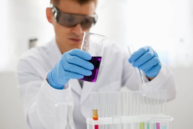 Bir erkek kimyager tüp cam içinde tutar