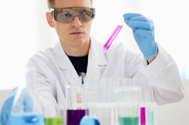 Bir erkek kimyager tüp cam içinde tutar