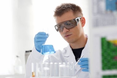 Bir erkek kimyager tüp cam içinde tutar