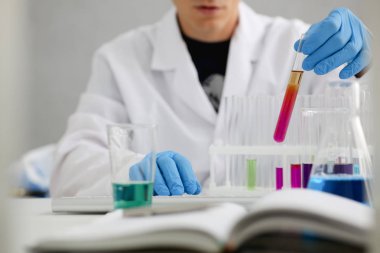 Bir erkek kimyager tüp cam içinde tutar