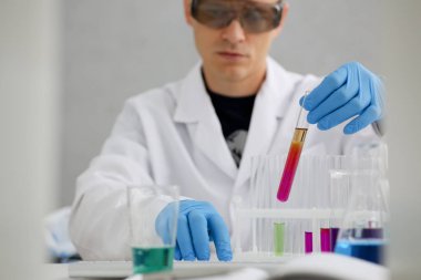 Bir erkek kimyager tüp cam içinde tutar