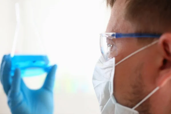 Un químico masculino sostiene tubo de ensayo de vidrio en — Foto de Stock