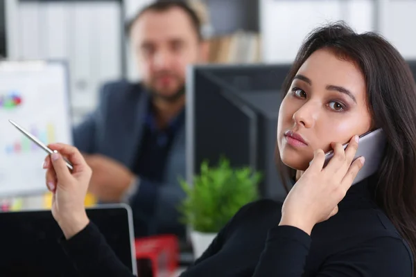 Joven bonita morena mujer en el trabajo de oficina con su jefe mantenga el teléfono inteligente en las manos — Foto de Stock