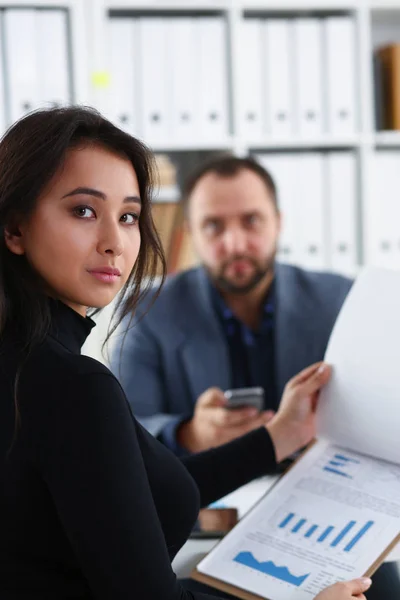 Joven hermosa mujer sentarse en silla a la mesa en la oficina en el gabinete de su jefe sujetar carpeta en brazos — Foto de Stock