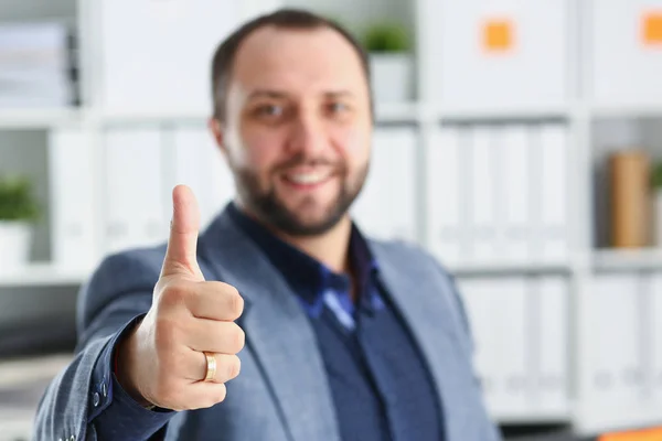 Nuori komea lupaava liikemies työskentelee toimistossa näytä iso sormi ylös — kuvapankkivalokuva