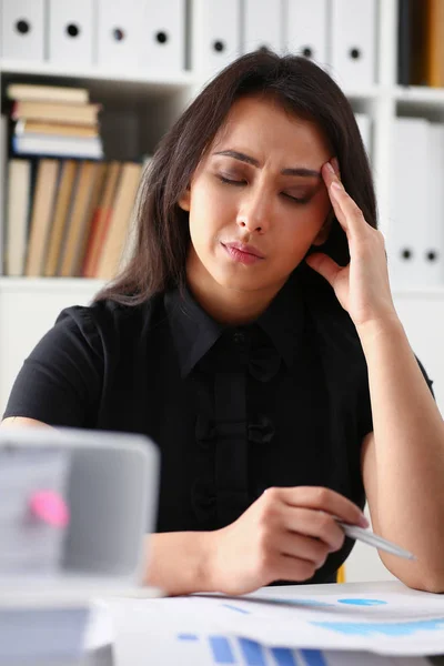 Moe en uitgeput vrouw kijkt documenten stutten van haar hoofd met haar handen — Stockfoto