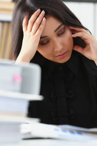 Moe en uitgeput vrouw kijkt documenten stutten van haar hoofd met haar handen — Stockfoto