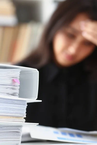 Moe en uitgeput vrouw kijkt documenten stutten van haar hoofd met haar handen — Stockfoto