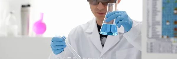 A male chemist holds test tube of glass in — Stock Photo, Image