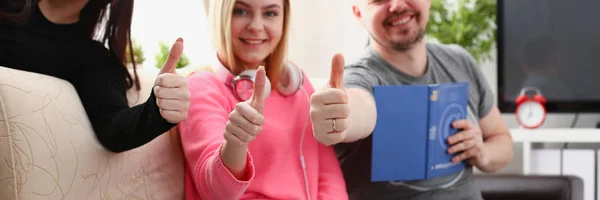 Gruppe von Freunden verbringen Zeit zusammen sitzen auf dem Sofa im Wohnzimmer zeigen großen Finger — Stockfoto