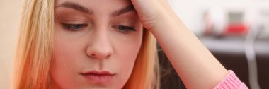 Genç sarışın womansit kanepe tutun Smartphone elinde güzel