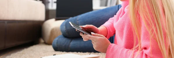 Jovem bonita loira womansit no sofá segurar smartphone em mãos — Fotografia de Stock