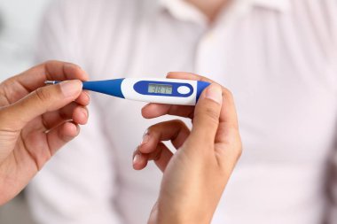 bir termometre tutan kadın doktor eller