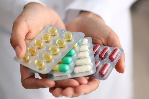 Feminino médico mão segurando pacote de diferente — Fotografia de Stock