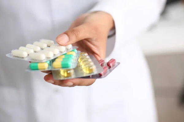 Feminino médico mão segurando pacote de diferente — Fotografia de Stock